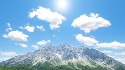 Fototapeta premium Sunlit Alpine Mountain Peak with Blue Sky and Clouds