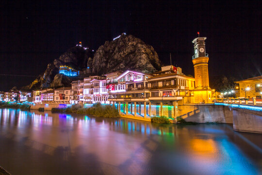 Old Ottoman houses and Clock Tower with night and mirrored view by the Yesilirmak River in Amasya. With blue mirrored - Powered by Adobe