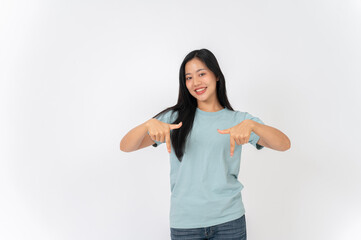 A woman standing on a studio background, pointing her finger downward as she recommend something.