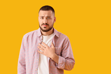 Apologetic young man on yellow background