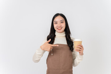 A smiling Asian female barista or cafe waitress pointing her finger at a hot drink cup in her hand.