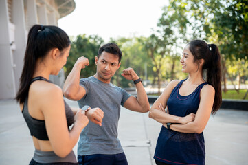 A group of sporty Asian friends enjoy a conversation outdoors after training together.