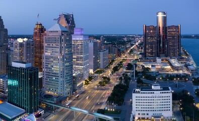 Fototapeta premium Detroit skyline at twilight, illuminated skyscrapers, busy streets, and urban landscape. Aerial view of city life. DOWNTOWN, DETROIT, MICHIGAN, UNITED STATES