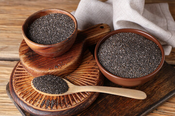 Bowls and spoon with chia seeds on wooden background