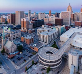Aerial view of a city's downtown core, featuring a spiral ramp parking garage. Urban landscape with various buildings and parked cars. DOWNTOWN, DETROIT, MICHIGAN, UNITED STATES