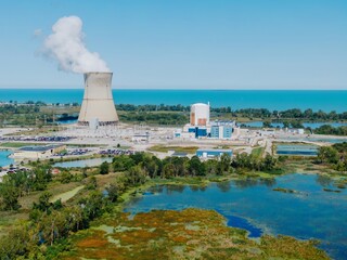 High-angle view of a nuclear power plant, surrounded by wetlands and a lake. Operating facility...