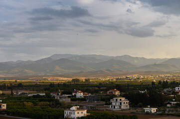 Fototapeta premium Breathtaking vistas showcase rolling hills and tranquil villages under a dramatic sky at dusk
