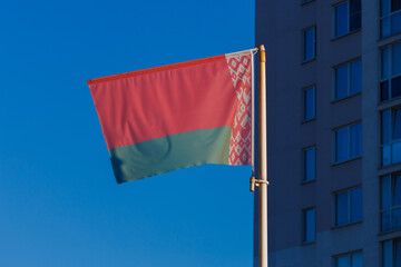 The flag of the Republic of Belarus on the street against the sky