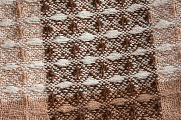 Brown plaid texture. Presentation of the fashionable color of 2025 mocha mousse. Warm, cozy shades of chocolate, beige, brown. The texture of a woolen plaid in close-up. The concept of home comfort