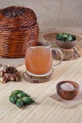 red ginger and areca nut brewed drink photographed in a studio setting with traditional Indonesian theme props