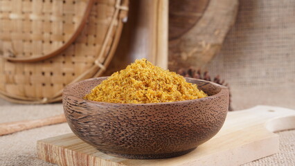 "Sambal Lingkung" is a typical food from Palembang, Indonesia. namely a type of floss made from catfish meat, in a wooden bowl photographed in the studio with a wooden theme prop