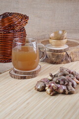 red ginger brewed drink photographed in a studio setting with traditional Indonesian theme props