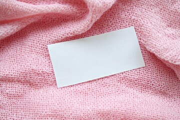 Elegant Blank White Clothes Tag Label on Pink Fabric Texture for Stylish and Professional Presentation