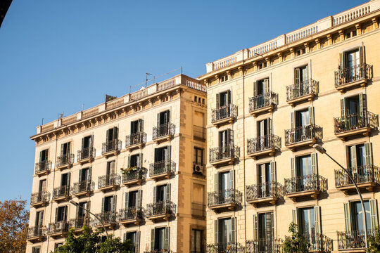 historic hotel building facade with open windows facing the sun on a beautiful and clear day in barcelona in spain