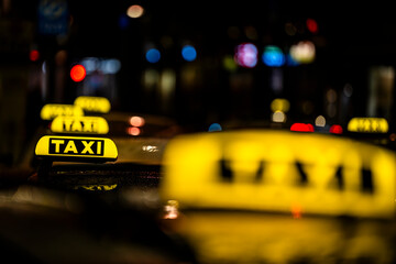 Neon taxi sign against the blurred background of the city center lights.