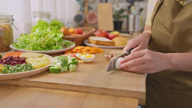 Close up of woman cooking healthy foods in kitchen in morning at home.