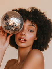 Festive Woman Holding a Shiny Silver Disco Ball Close to Her Face