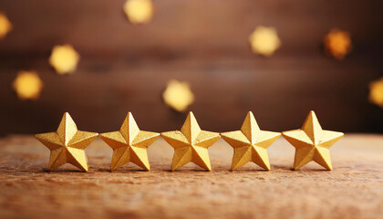 5 five golden stars on wooden table. Highest level of service, customer or product feedback, ratings