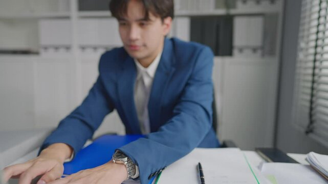 Asian businessman turning on laptop computer while working in office. 