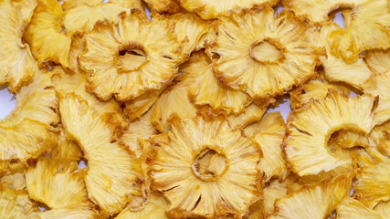 Crisps, handmade dried pineapple snacks, fruit background, selective focus