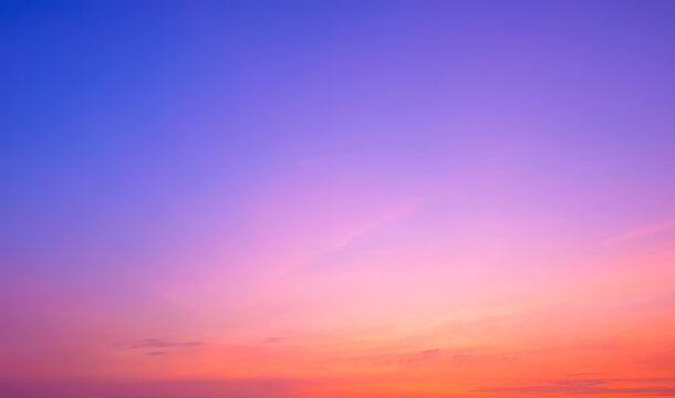 Evening romantic sky background with colorful pink orange natural gradient light and thin cloud on blue romantic twilight sky after sundown