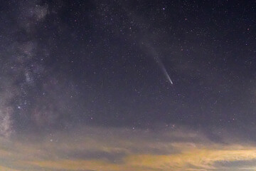 山奥の展望台より、没後まだ夕焼色が残る空に天の川が輝き始め、彗星も長い尾が見えて来ました、夕焼色した雲が残る空で左側に天の川で右側に彗星の横構図です。