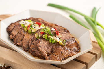 Taiwanese braised beef shank slices in a plate on white table background.