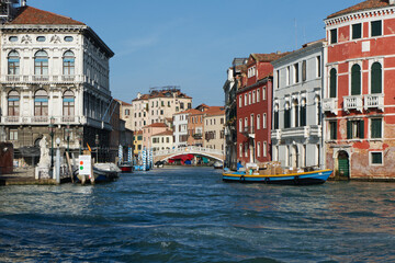 A picturesque canal in Venice, Italy, with colorful historic buildings and a small bridge, showcases the city's unique architecture and charm.