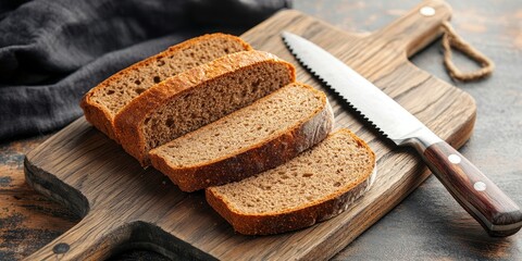 Top view of rye bread slices alongside a knife on a wooden cutting board, showcasing the texture and color of rye bread in a pleasant kitchen setting. Rye bread is a versatile staple.