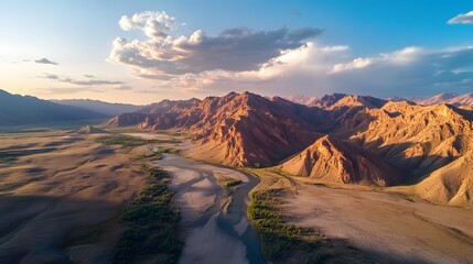 Fototapeta premium Aerial view of Pe Altai Mountains baPed in golden light, wiP rugged peaks casting dramatic shadows, in 4K resolution