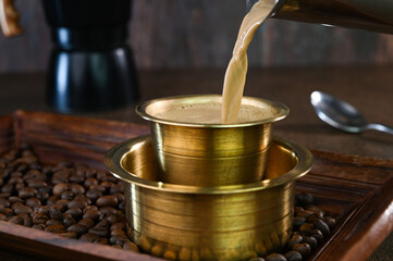 Serving Indian filter coffee in a cup.