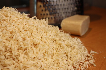 Housewife grated a bar of laundry soap on a hand washing grater