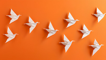 Beautiful white origami birds on orange background, flat lay