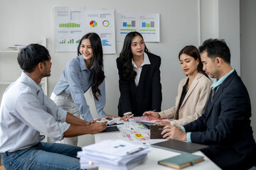 A group of people are sitting around a table, discussing something