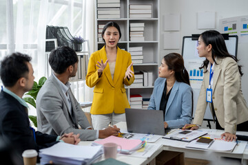 A group of people are gathered around a table in a conference room