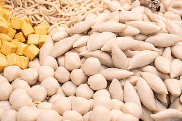 A large pile of white food with a yellowish substance on top. The yellowish substance is tofu, which is a type of soybean curd. The pile of food is made up of various types of food, including noodles