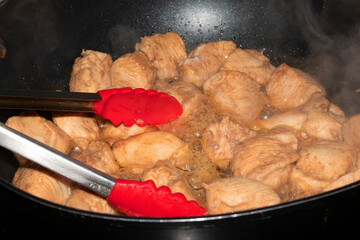 Chicken Pieces Frying in a Wok Pan Close Up