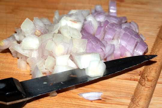 Chopped Onion On Wooden Board with a Knife