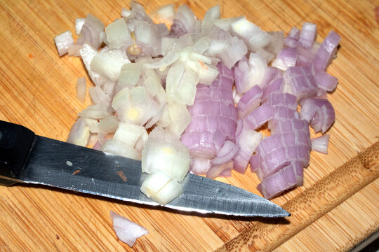 Chopped Onion On Wooden Board with a Knife