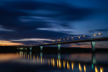 View of the road bridge at night. Glowing lights on the bridge illuminate the road. Bridge over the Vyatka River