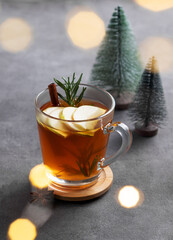 Homemade apple punch with fresh apples, cinnamon and rosemary in a cup on a dark background