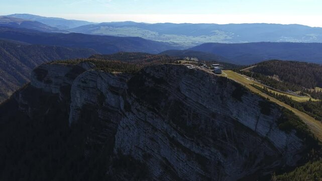 Captured from above, the image highlights Fort Verena and surrounding rugged mountains in Italy, showcasing its natural beauty. circle dolly shot