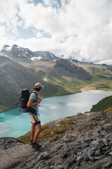 Hiker Enjoying Norwegian Mountain Views with Turquoise Fjord Below