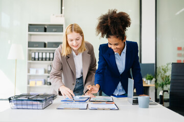Female discussing new project with Female colleague. Young woman talking with young african woman