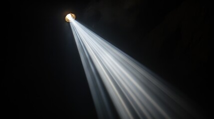 Light beam through hole in dark ceiling.