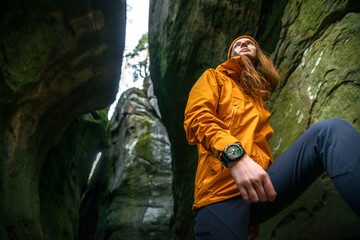 Defocused Female Traveler Exploring a Cave in a Canyon with Focus on Her Hand and Travel Watch