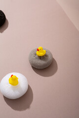 Still life washclothes set  and bath duck on beige surface hygiene and cleaning concept