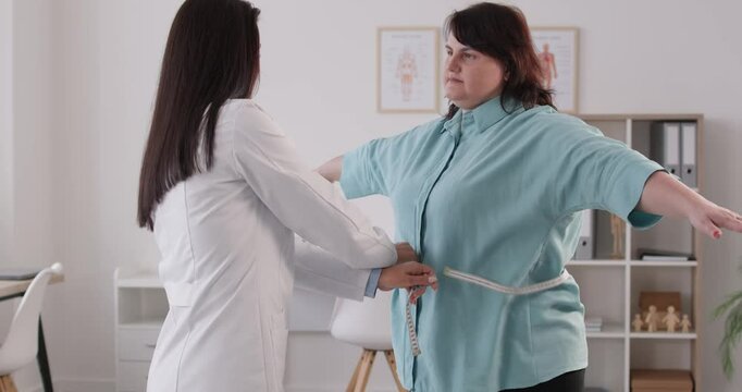 Doctor check fat large overweight plus size chubby woman measure waist tell stop overeat lose weight start wellness lifestyle lower cardiovascular heart disease diabetes metabolic syndrome risk danger