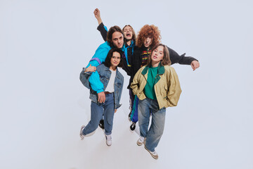 Five young stylish people, men and women in their 20s wearing stylish retro inspired outfits,...