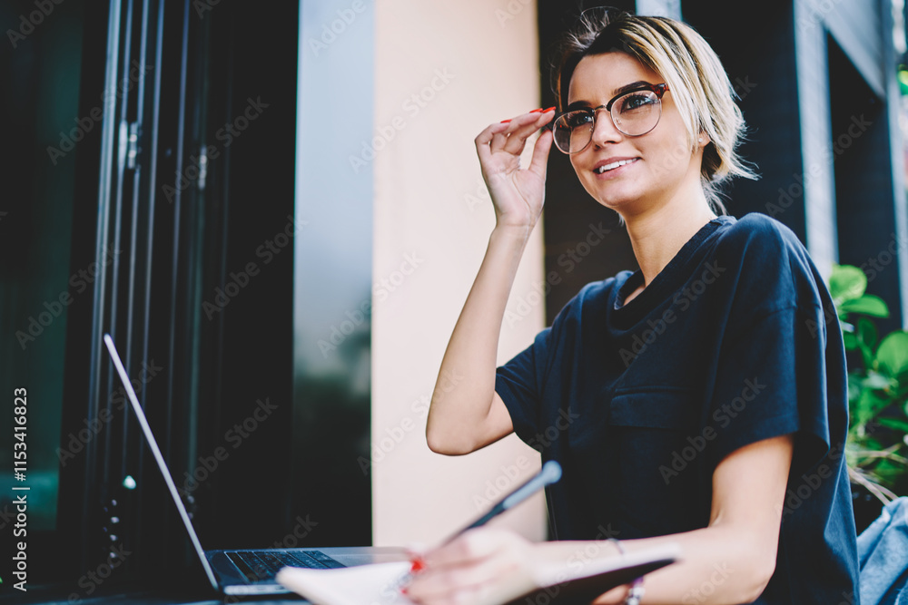 Poster smiling fashionable hipster woman distracted from work on modern laptop computer, female programmer 